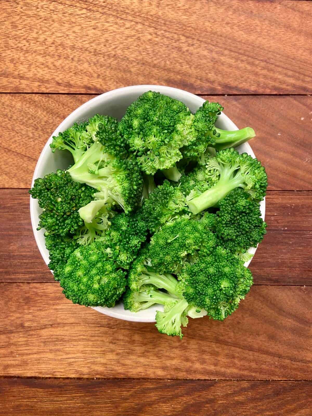 Chopped broccoli florets in a small bowl.