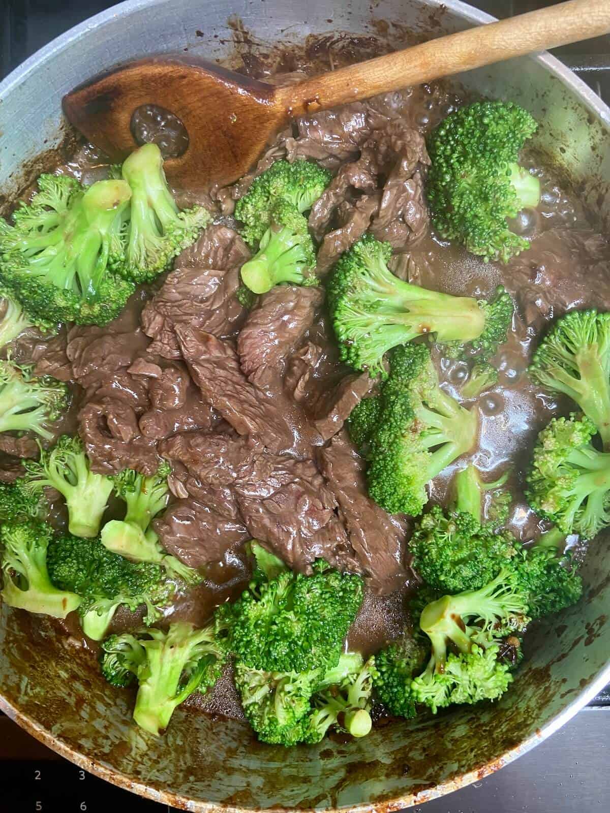 Cooking the meat and broccoli in a pan.