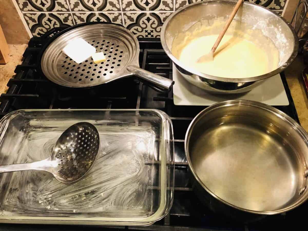 Batter, water, sieve, and baking dish - in position.