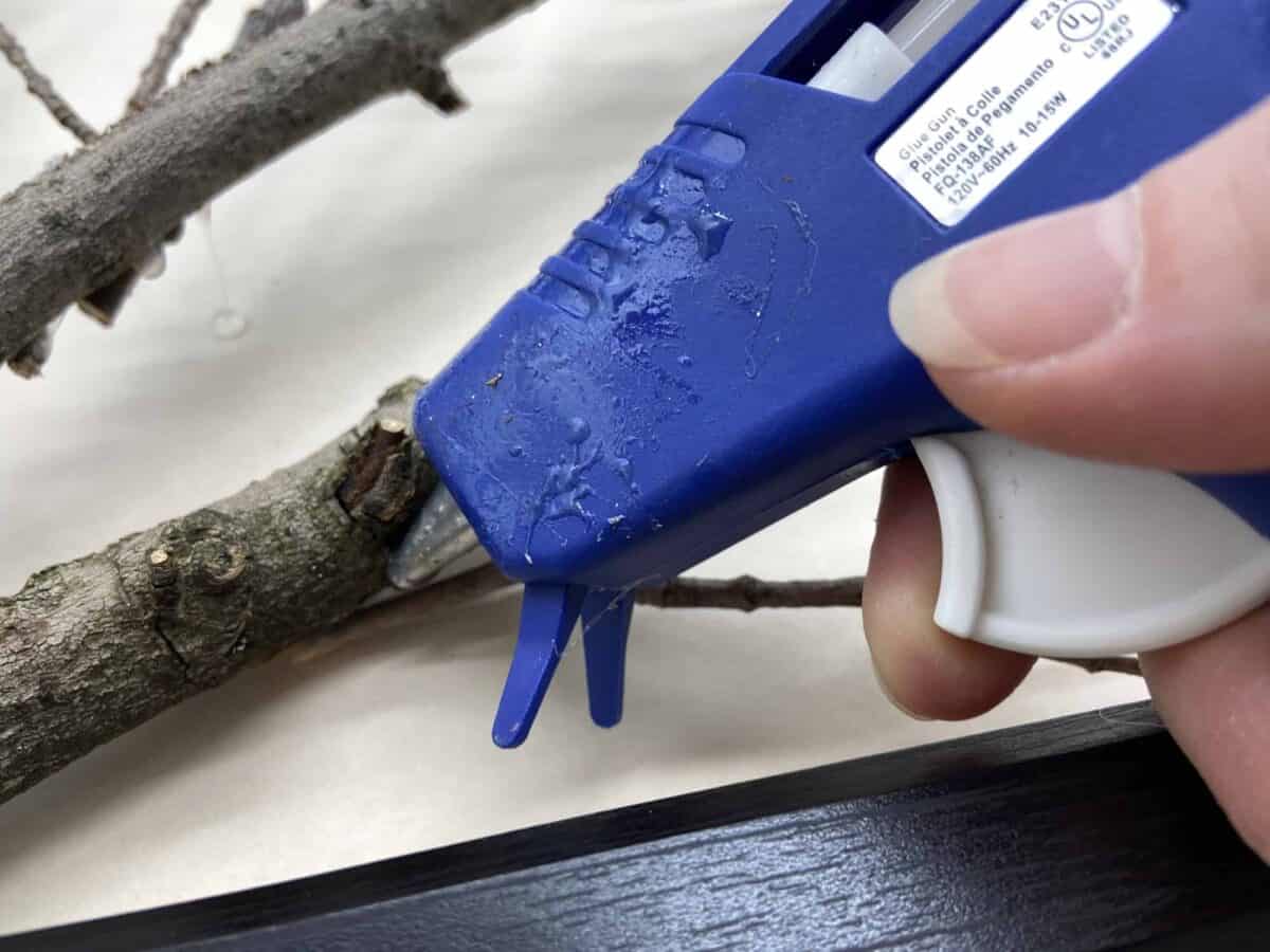 Using hot glue gun on branches.