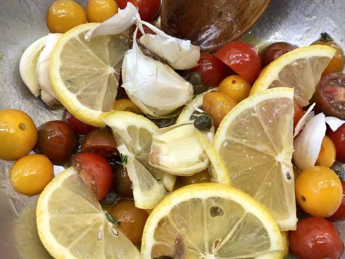 Fresh, healthy ingredients of lemon, tomatoes, garlic, and capers.