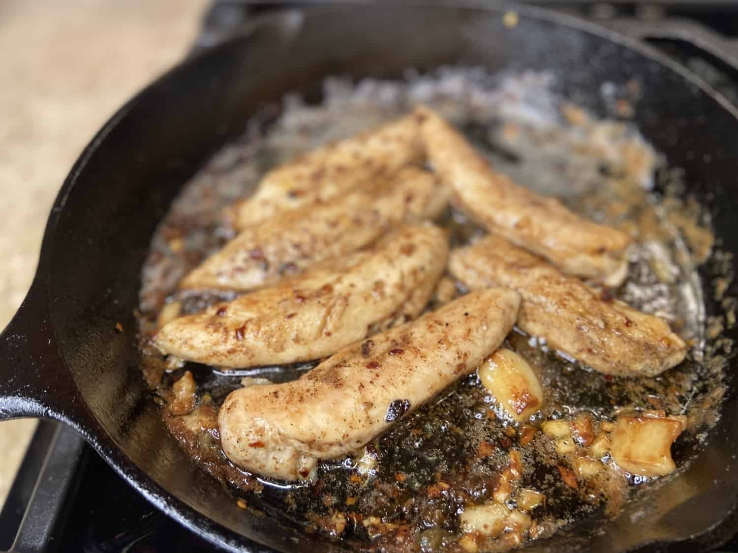 Cooking the chicken in a cast iron pan.