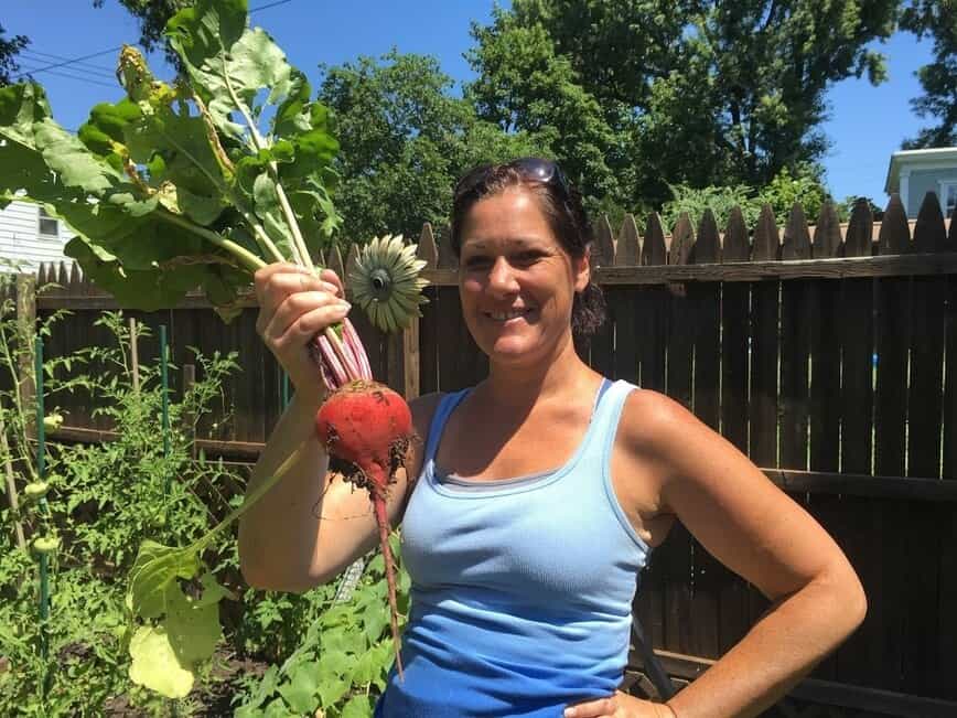 Viana holding up a fresh beet from our backyard garden.