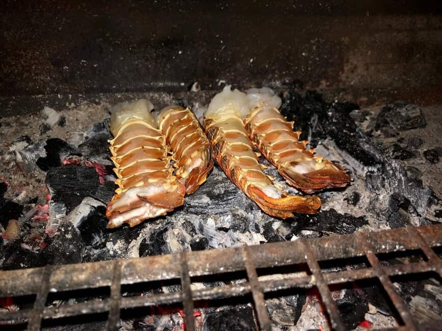 Lobster tails grilled directly on the charcoals.