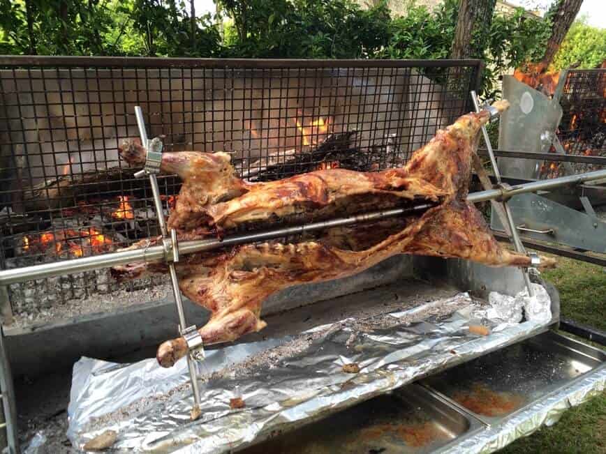 Whole pig on rotisserie grill.