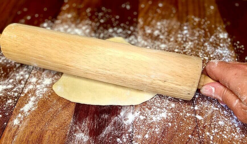 Rolling out dough on a lightly floured cutting board.