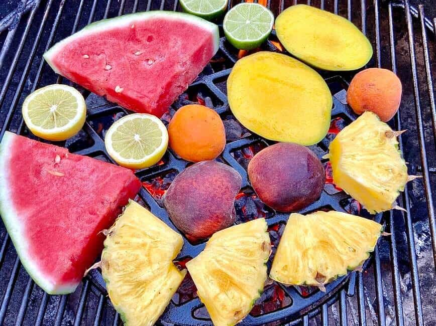 Fruits placed directly over hot coals on grill grate.