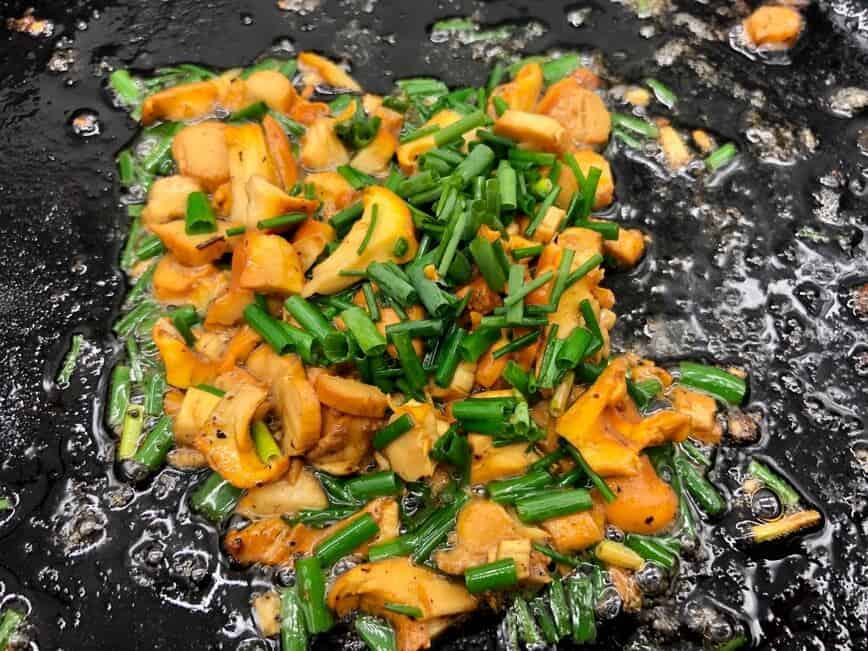 Sauteing chanterelles with oil, butter, salt, and chives.