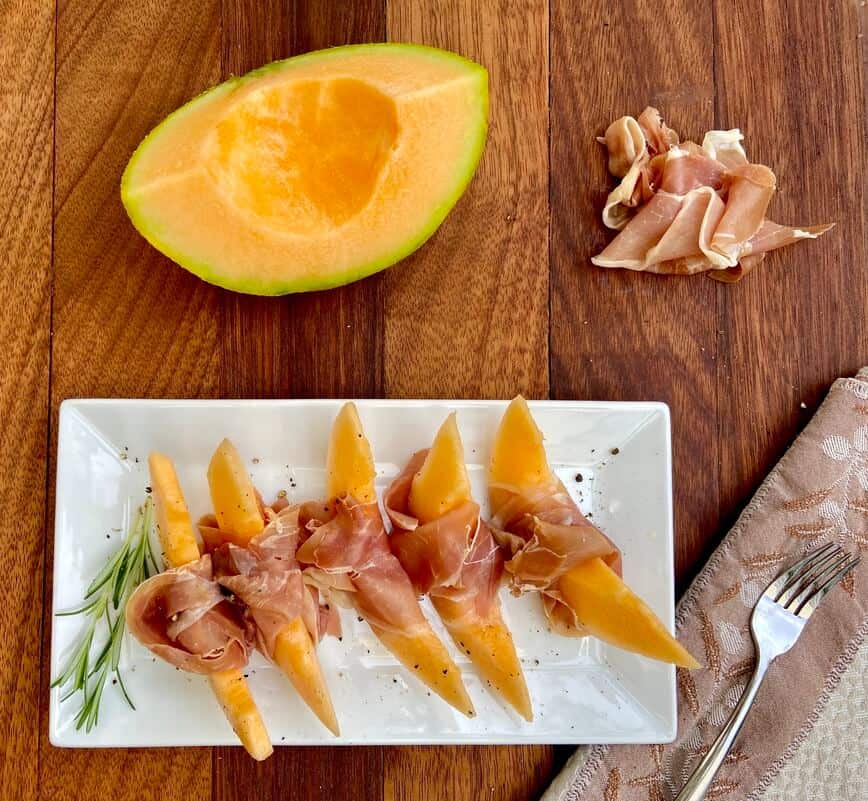 Slices of prosciutto and melon on a plate.