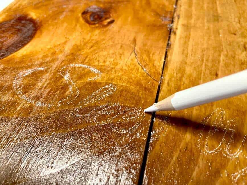 Lightly outlining the needle marks with a white pencil.