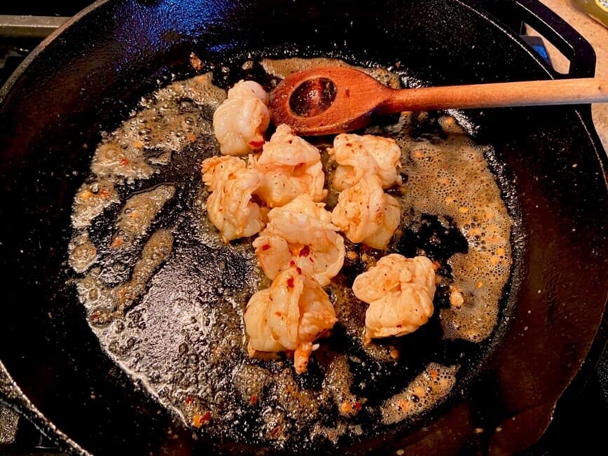 Sauteing shrimp in a cast iron pan.
