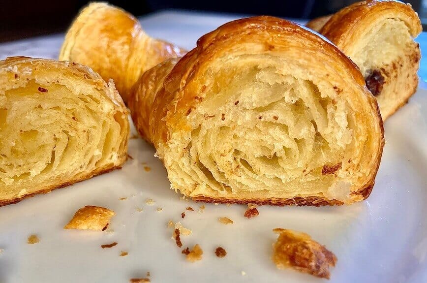 A croissant cut in half, showing all the flaky layers inside.