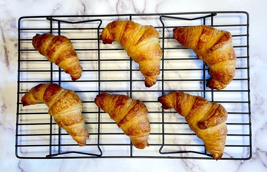 Croissants cooling on a rack.