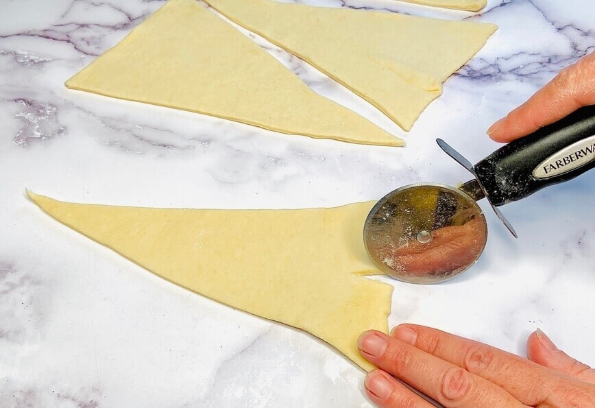 Cutting a notch into the wide end of dough.