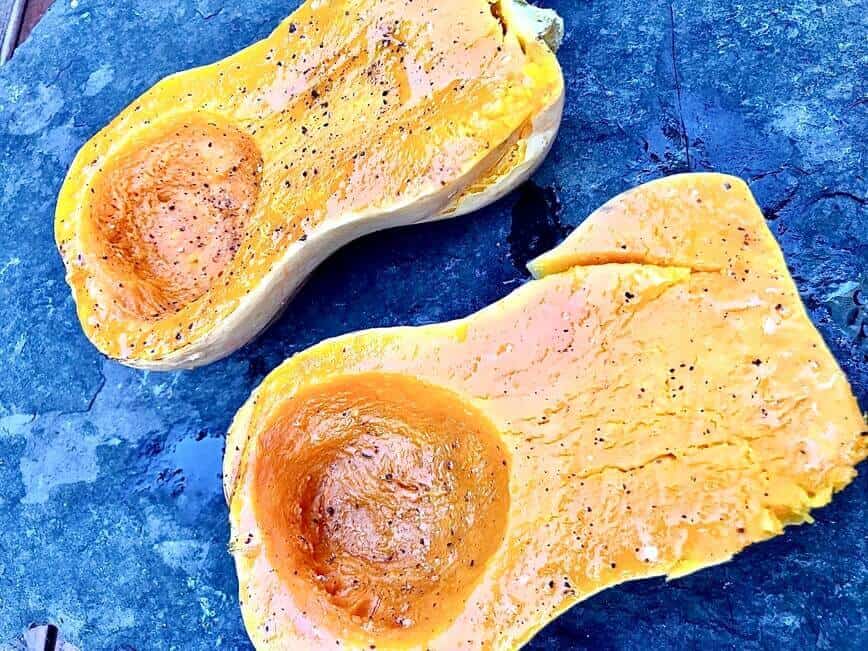 Halved squash seasoned with extra virgin olive oil, salt, and pepper.