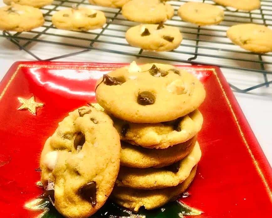 A stack of cookies on a red Christmas plate.