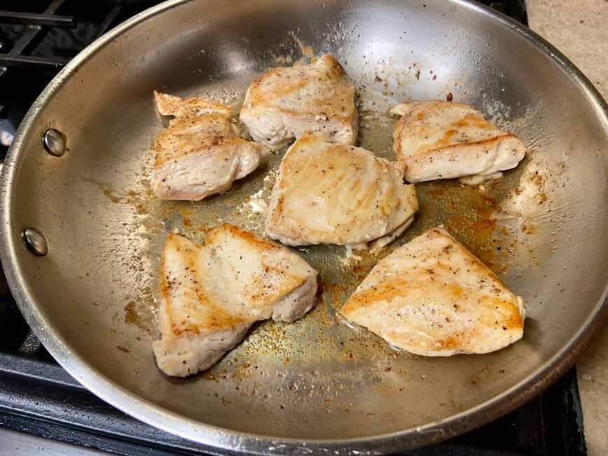 Cooking the chicken in a large pan.