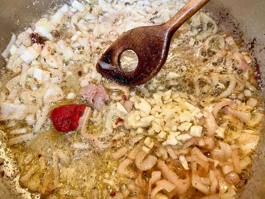 Sauteing onion, garlic, tomato paste, anchovy paste, and oregano.