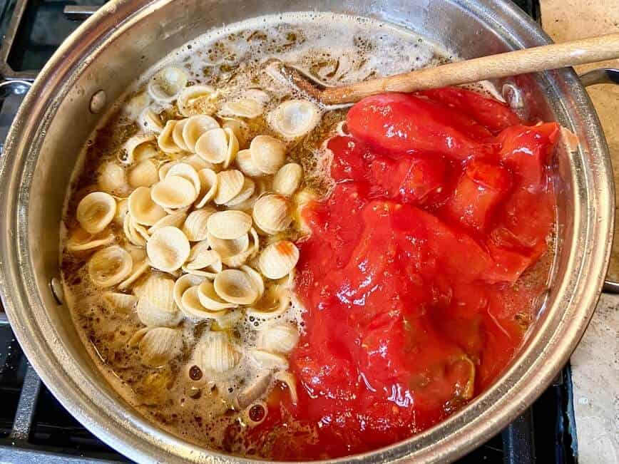 Cooking pasta, beef stock, and tomatoes.