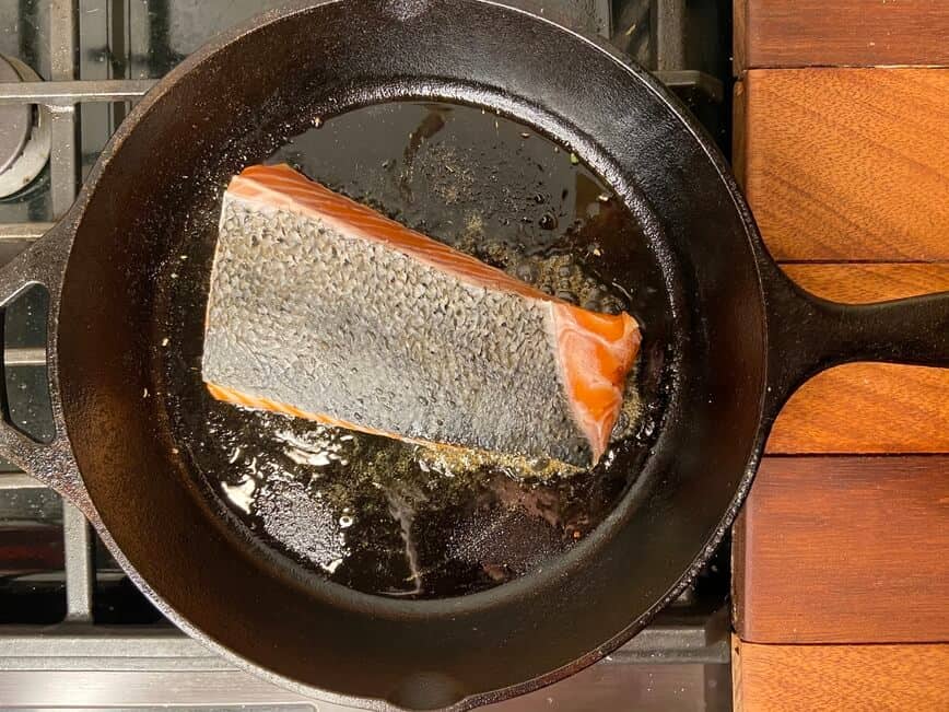 Cooking the fish in a cast iron pan.