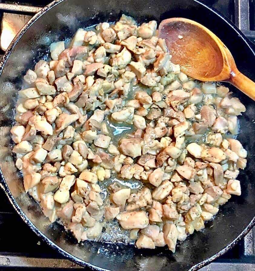 Cooking chicken in cast iron pan.
