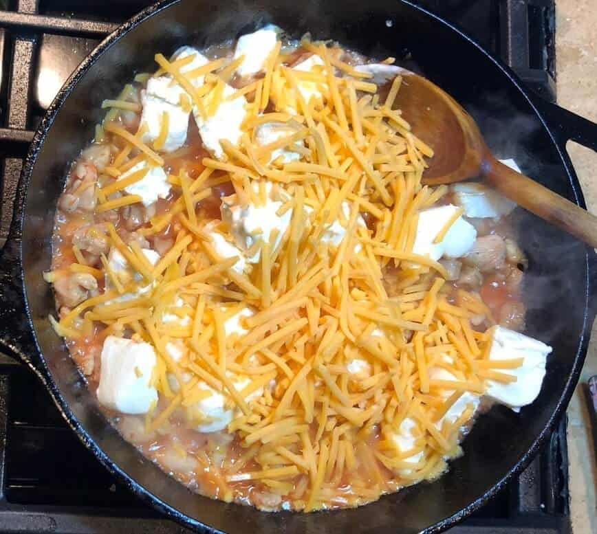 Adding cream cheese, cheddar cheese, and ranch dressing to the pan.