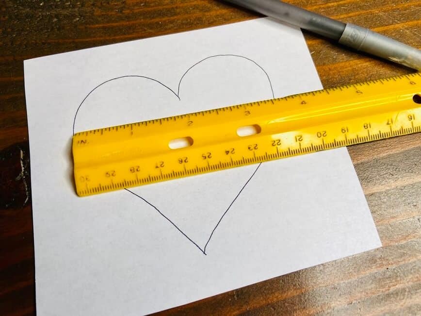 Paper with heart drawn on it, with pen and ruler.