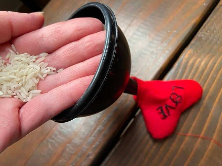 Filling heart with rice through a small funnel.