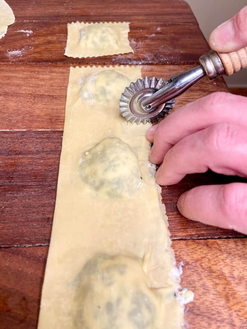 Cutting ravioli with rotary cutter.