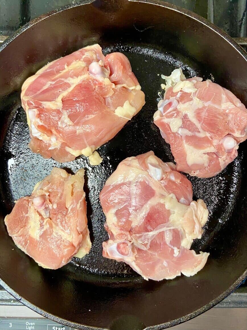 Cooking chicken in a cast iron pan.