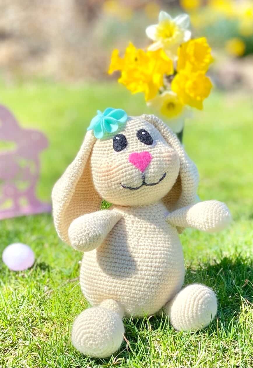 Doll outside with fresh flowers and Easter eggs.