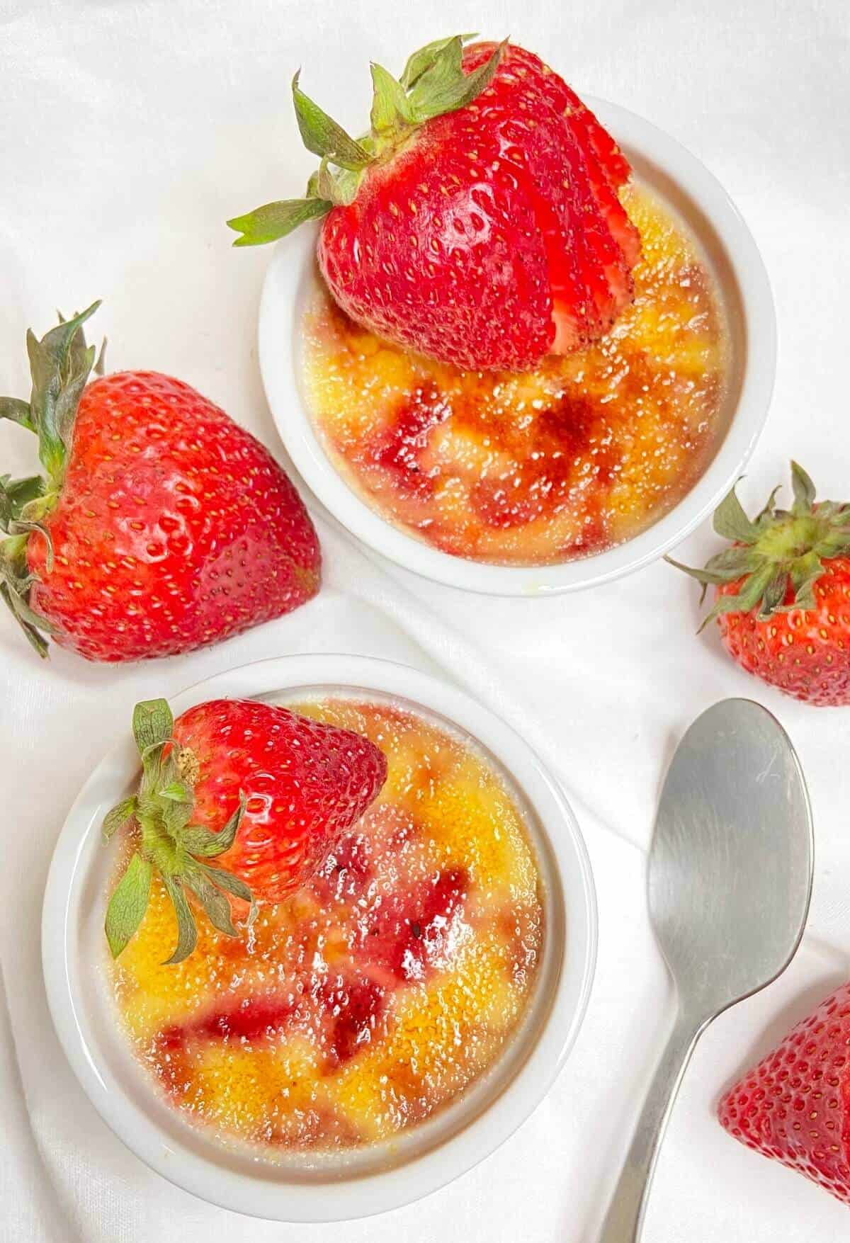 Finished creme brulee with strawberries on top.