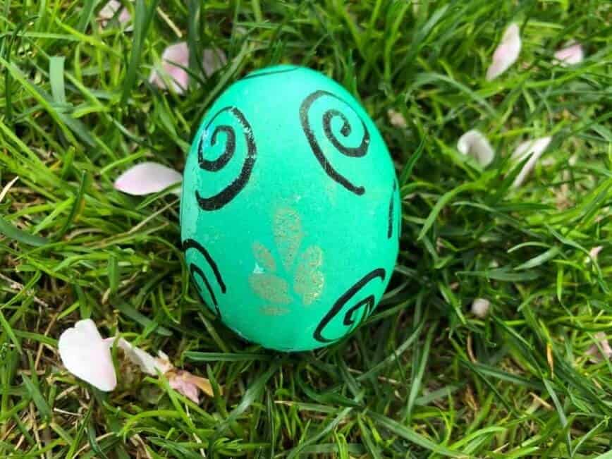 Turquoise egg with black curlicues and gold sparkle.
