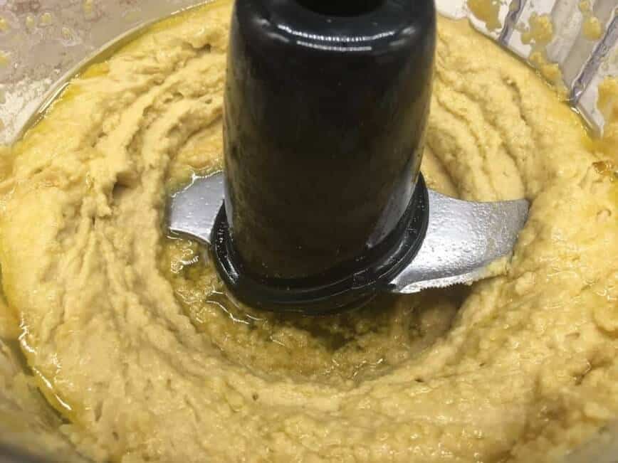 Mixing hummus ingredients in food processor.