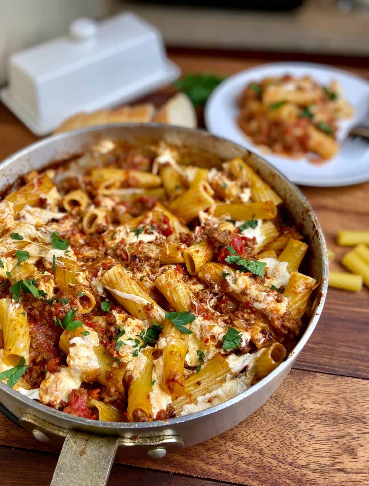 Baked pasta in pan on wood table.