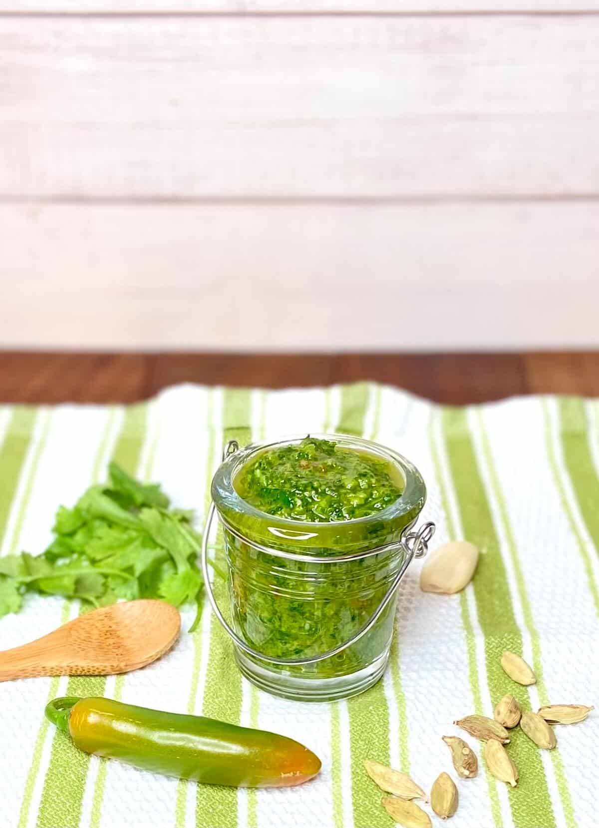 Finished sauce in a jar on a green and white striped towel.