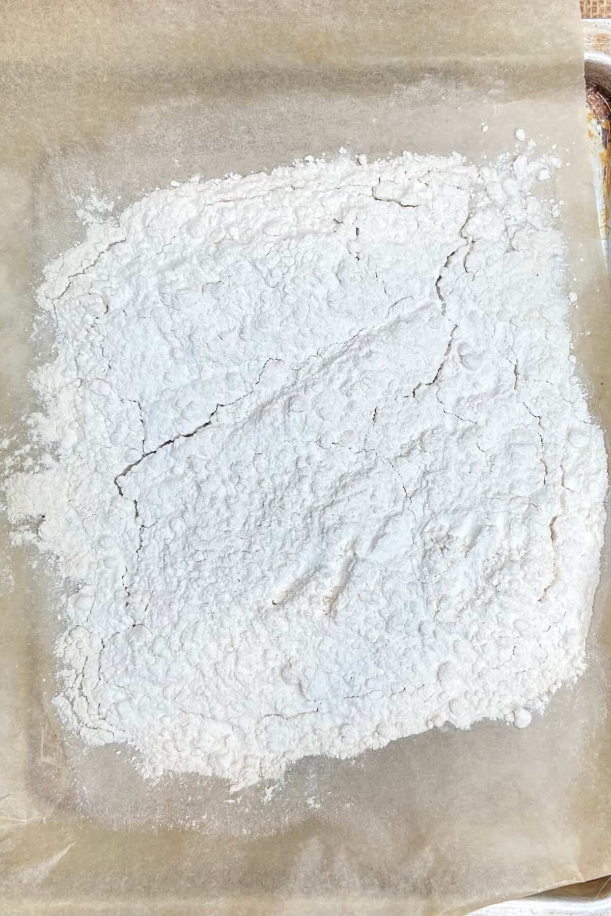 Flour on a parchment lined baking sheet.