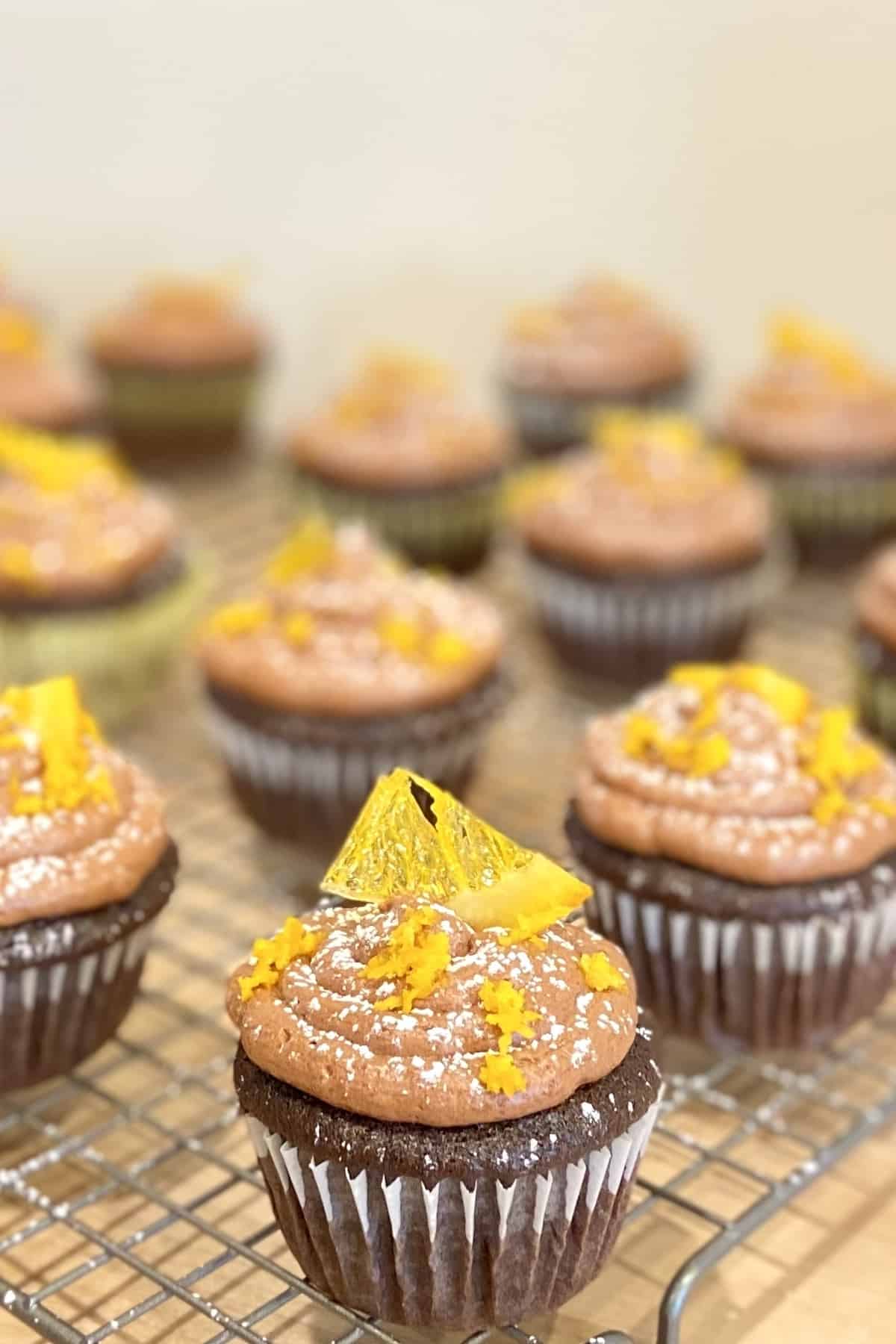 Cupcakes with a tiny wedge of candied orange on top.