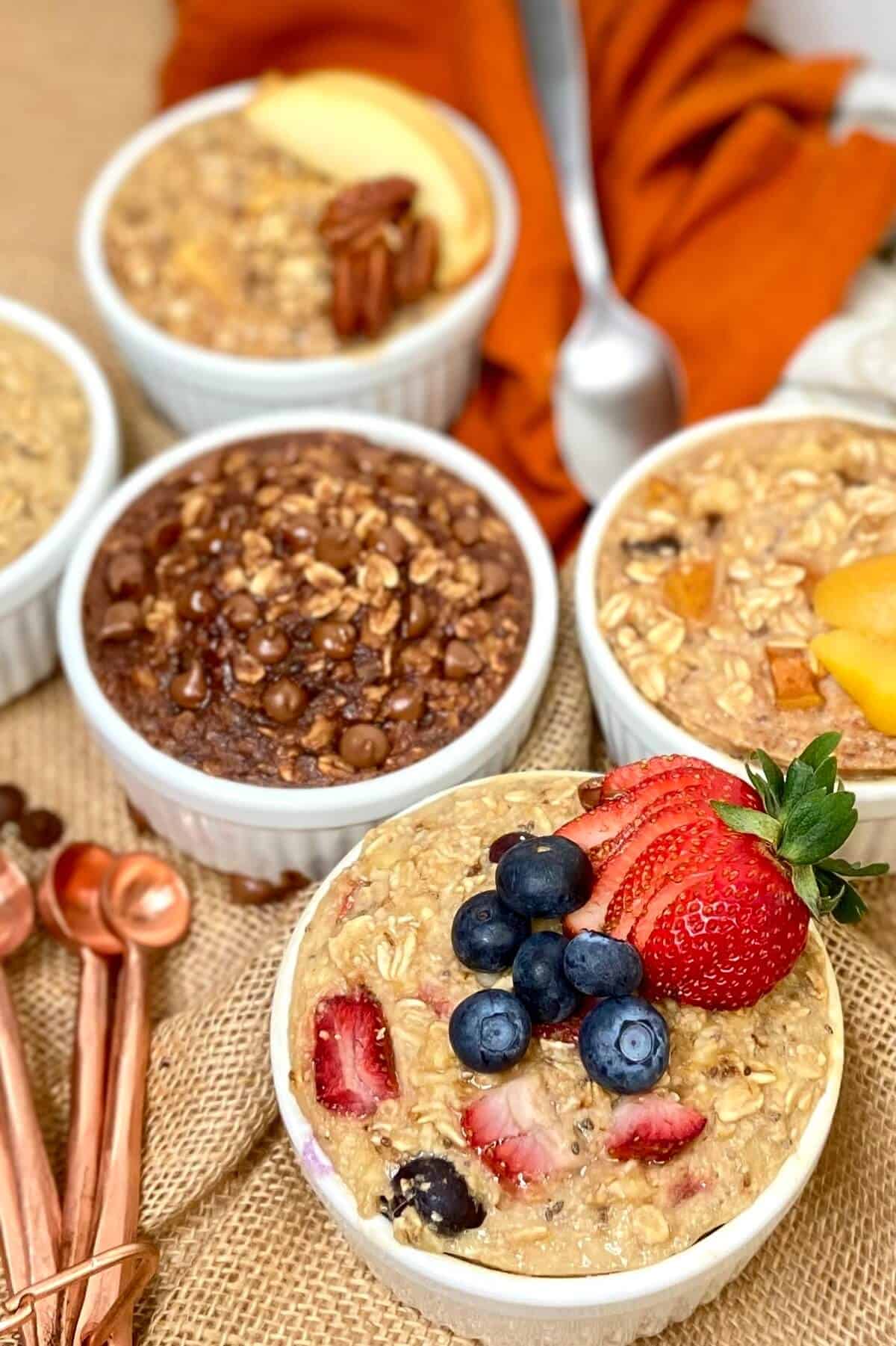 All different flavors of oatmeal on a burlap covered table.