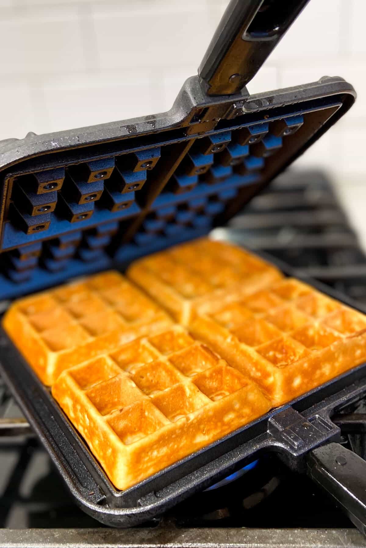 Waffles cooking in waffle iron.