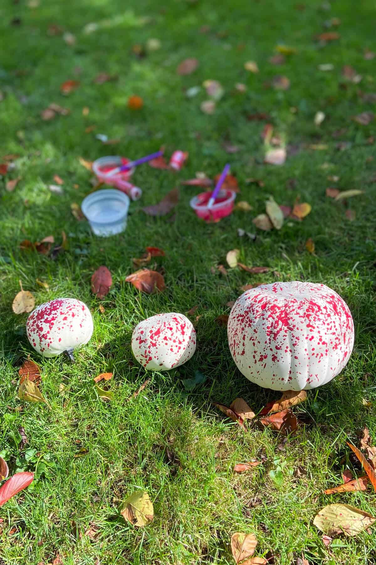 Painting pumpkins in the grass.
