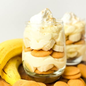 Layers of pudding, cookies, sliced bananas, and whipped cream in a glass.