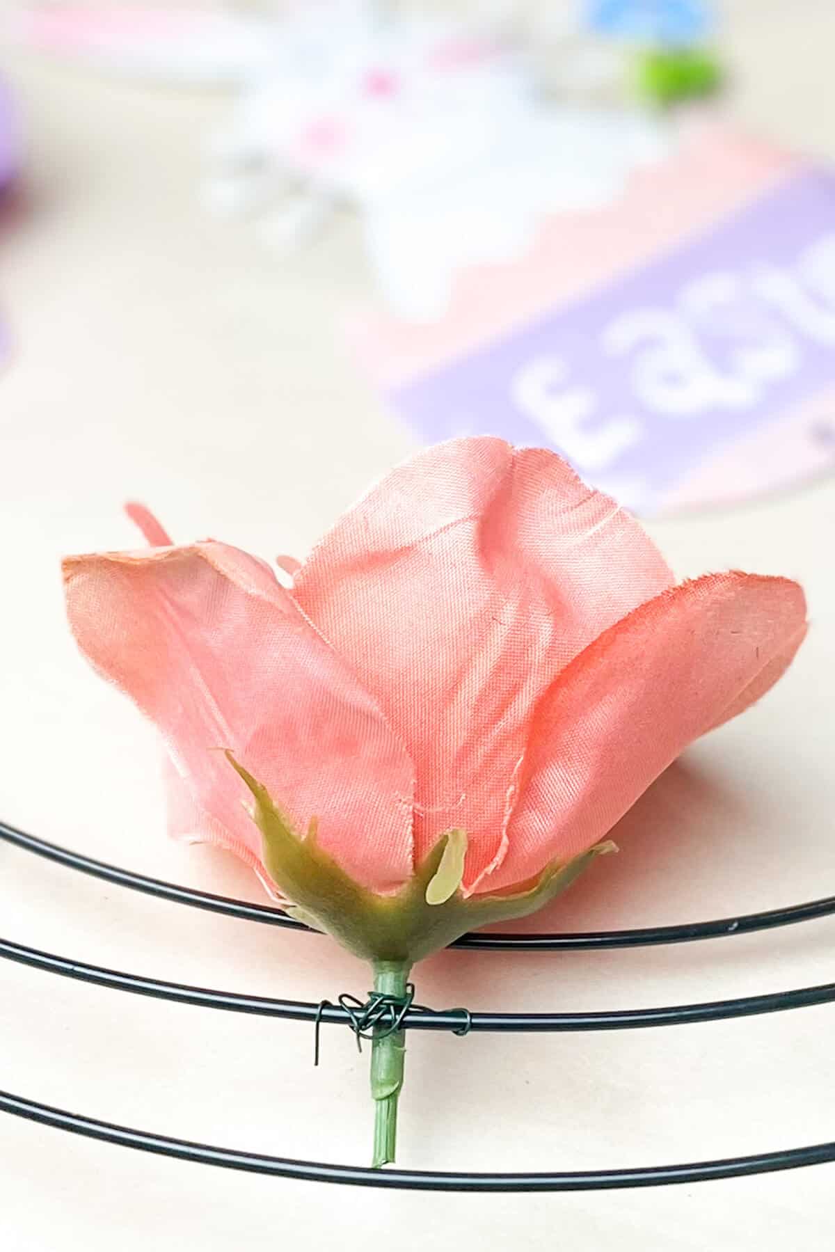 Adding the flower to the wreath form by wrapping wire around.