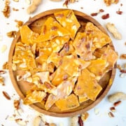Quick & Easy Nut Brittle, in a round wooden tray.