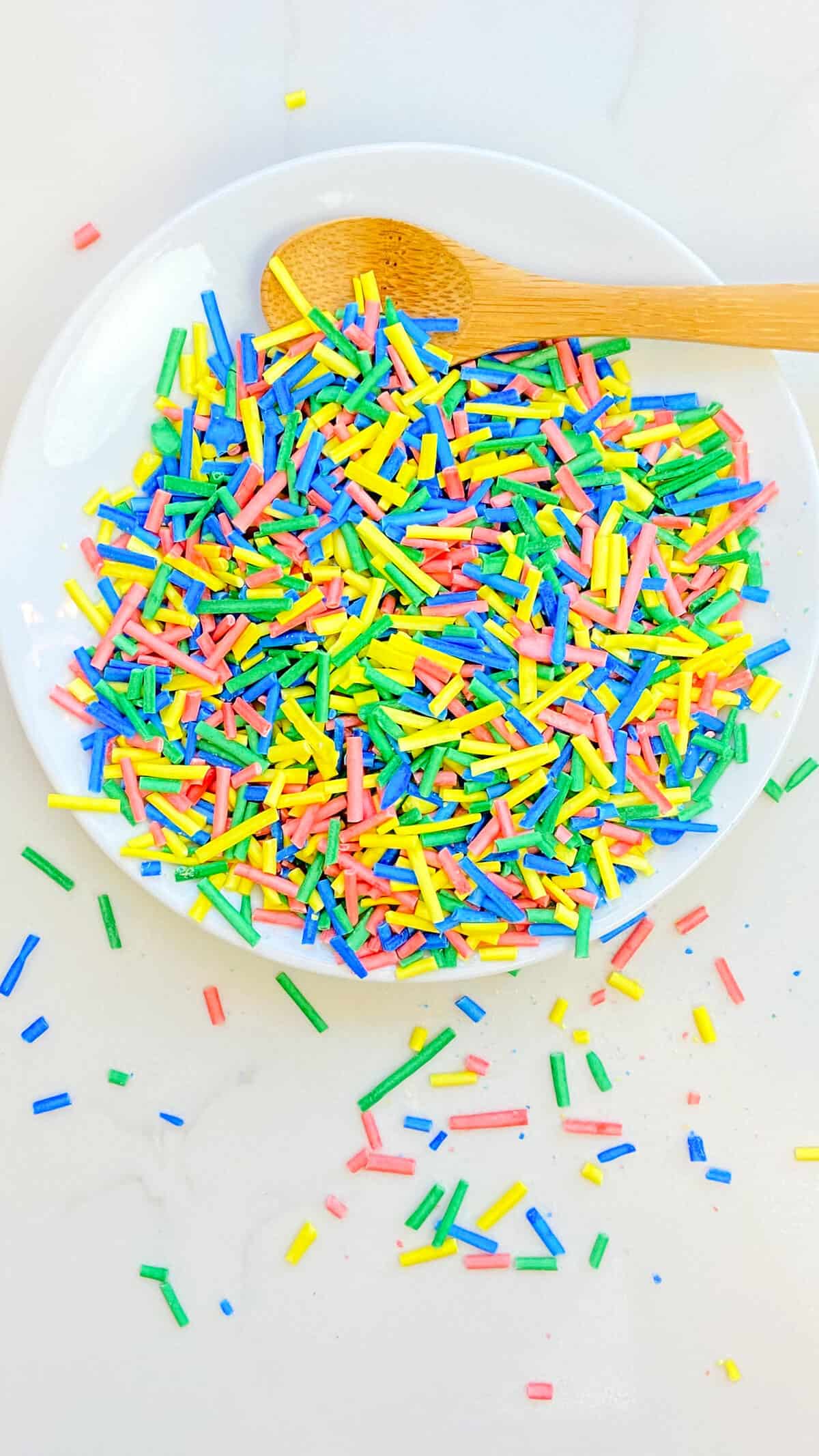 A plateful of colorful sprinkles, overflowing onto the countertop.