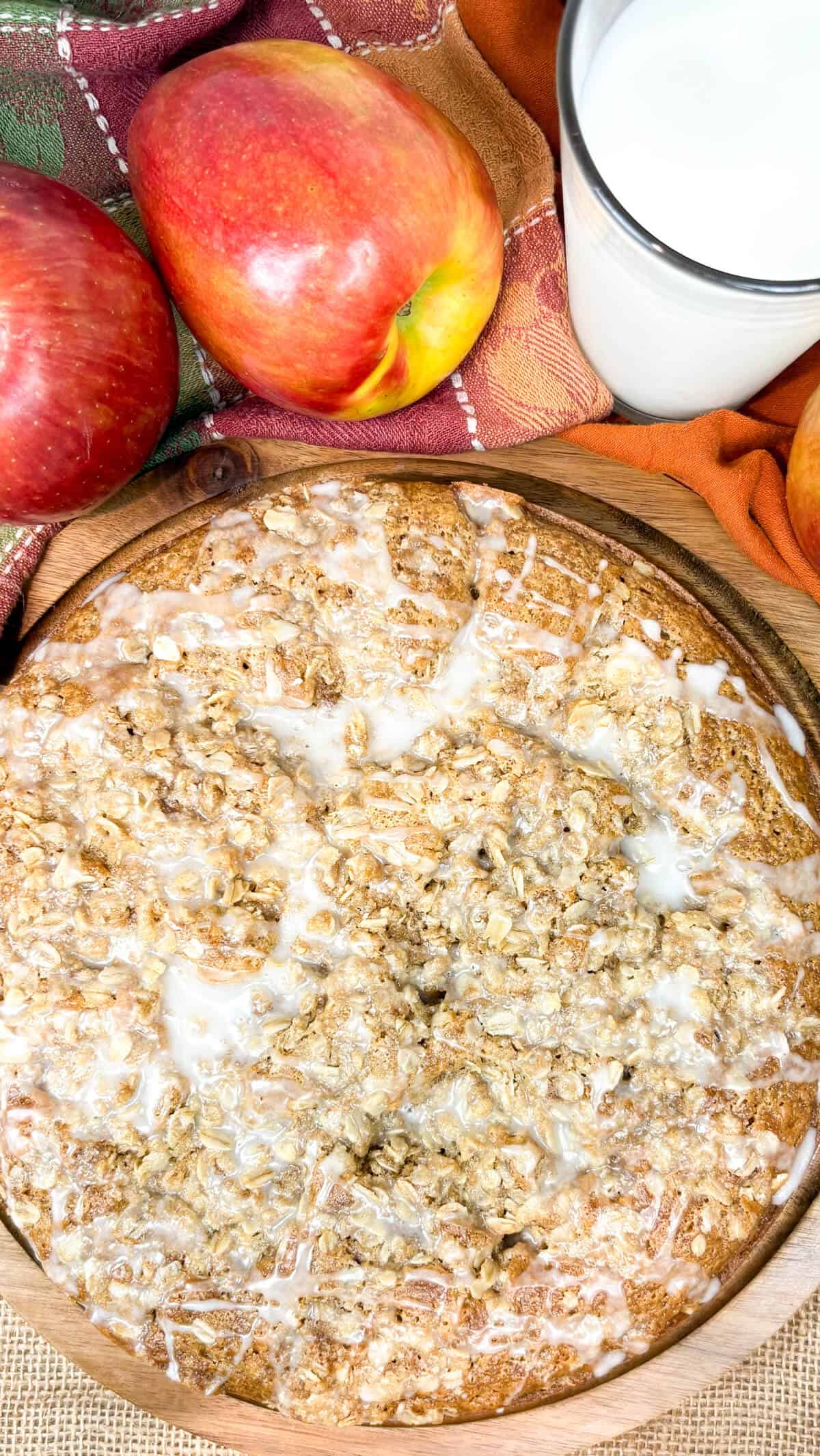 Whole cake, with apples and a glass of milk.
