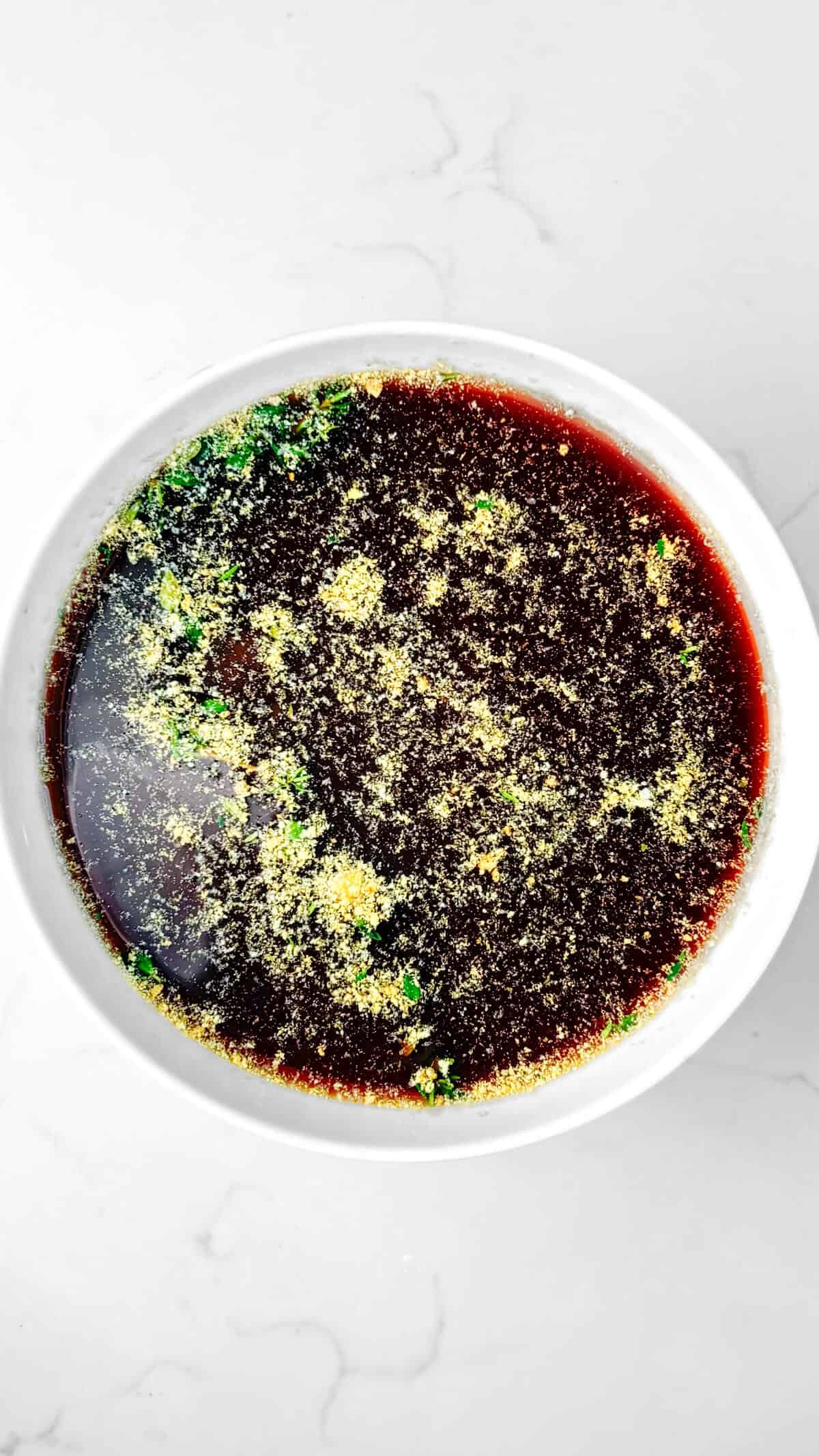 Sauce and seasoning, whisked together in a bowl.