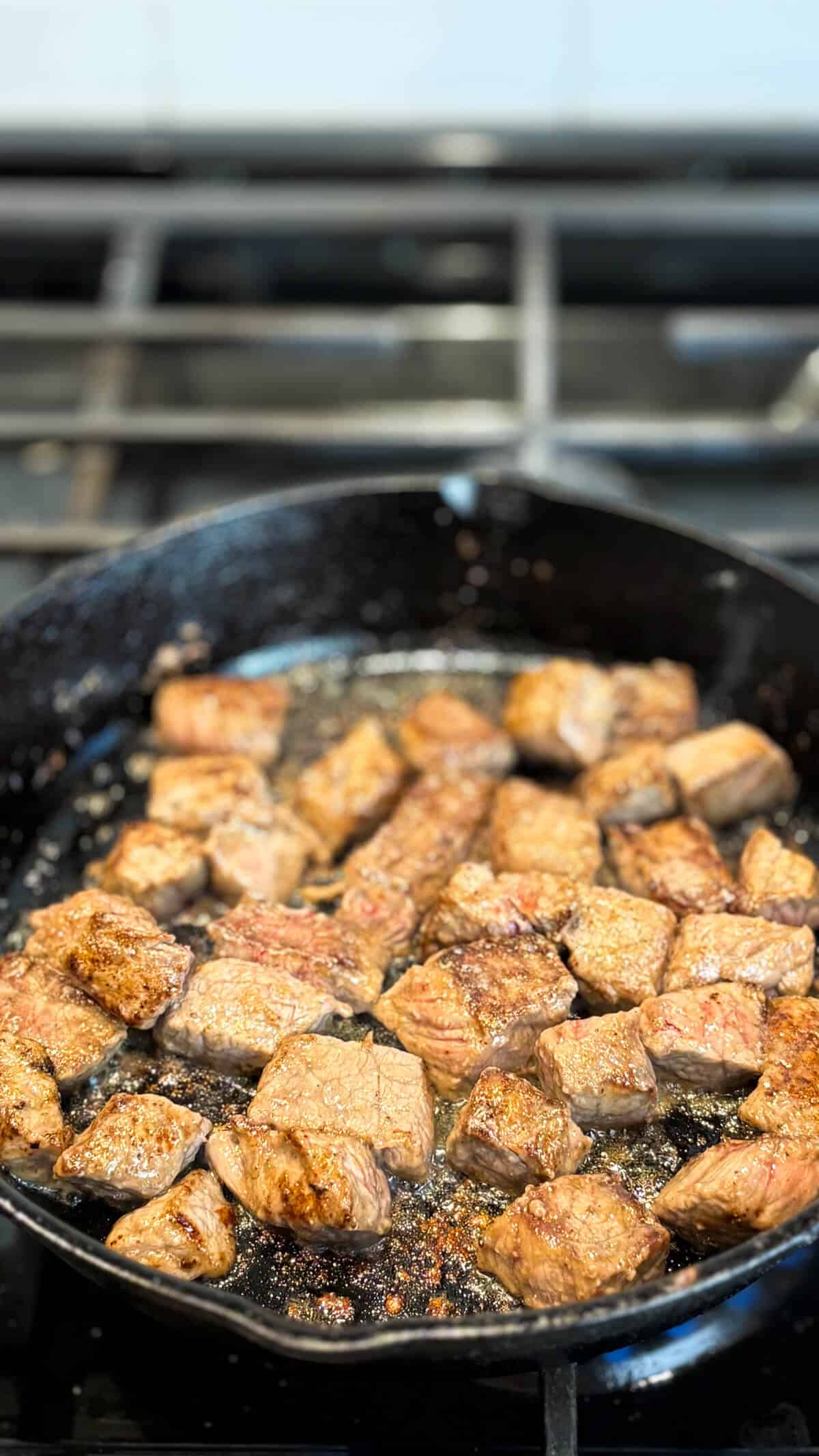 Searing the beef in a pan.