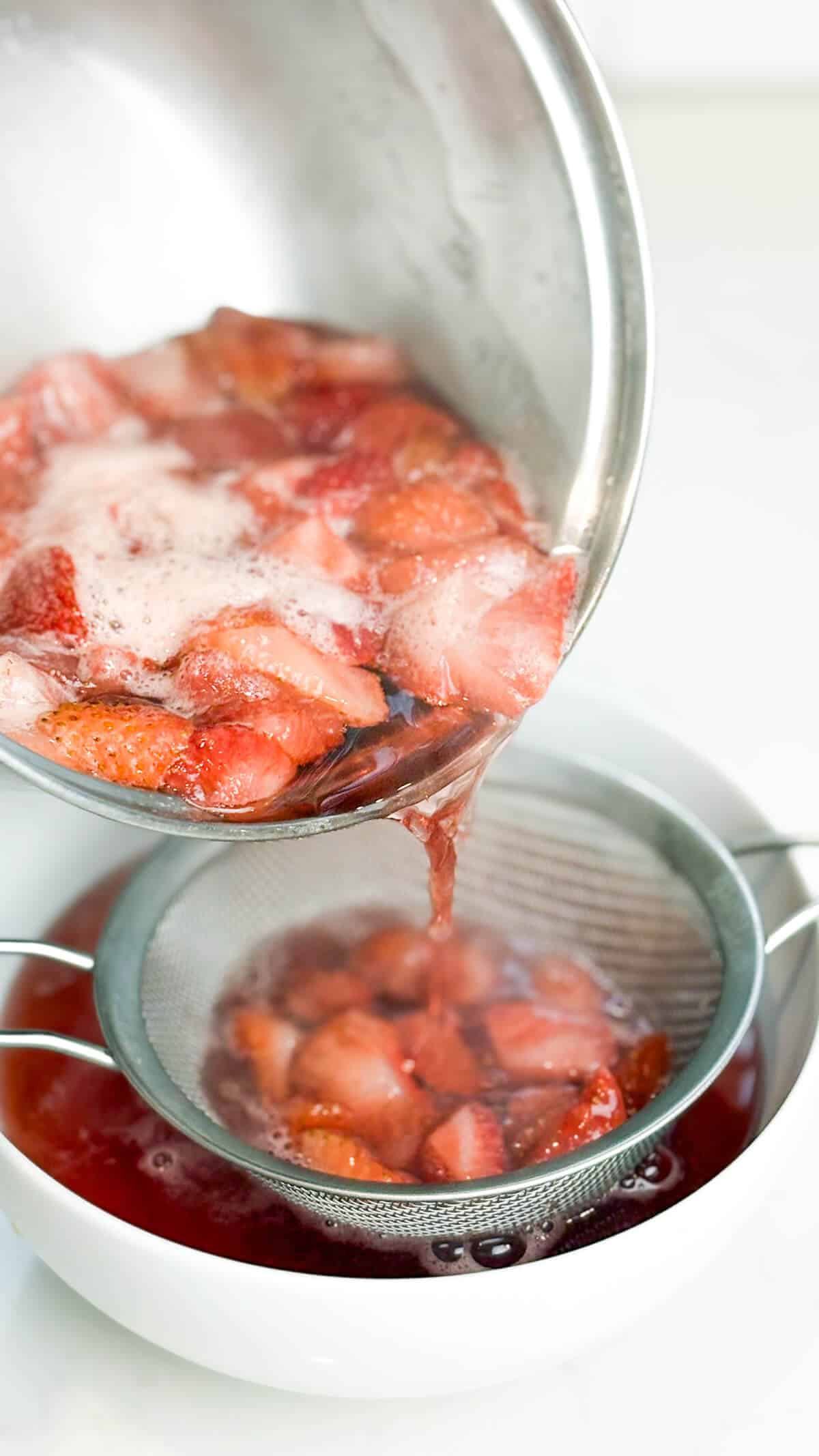 Pouring simple syrup through fine mesh sieve.