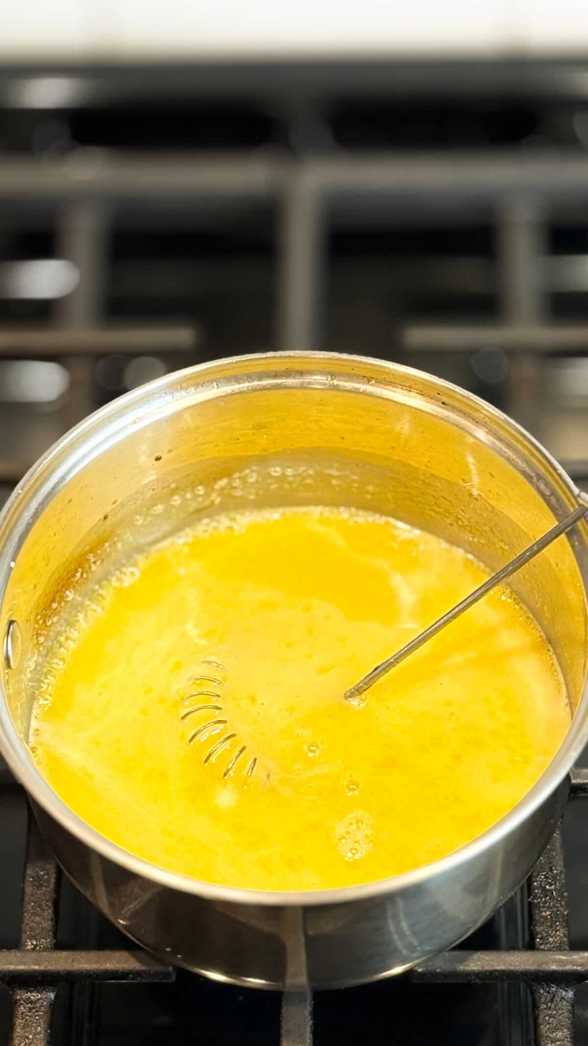 In pot on stove with whisk.